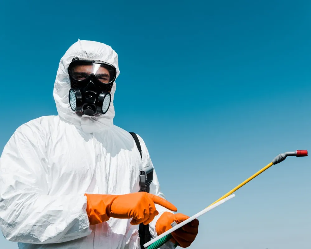 Exterminador equipado con traje de protección y maquinaria, preparado para aplicar tratamientos seguros según la Constancia de fumigación vs certificado de fumigación Cofepris.