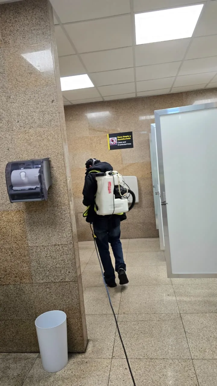 Especialista de Insectalia desinfectando baños de cafetería para prevenir bacterias y plagas en la industria gastronómica.